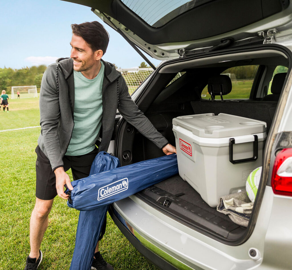 A man going to a sporting event with his Coleman gear.