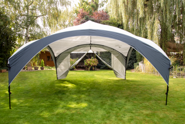 Fastpitch Shelter Sunwall with Door set up in a garden.