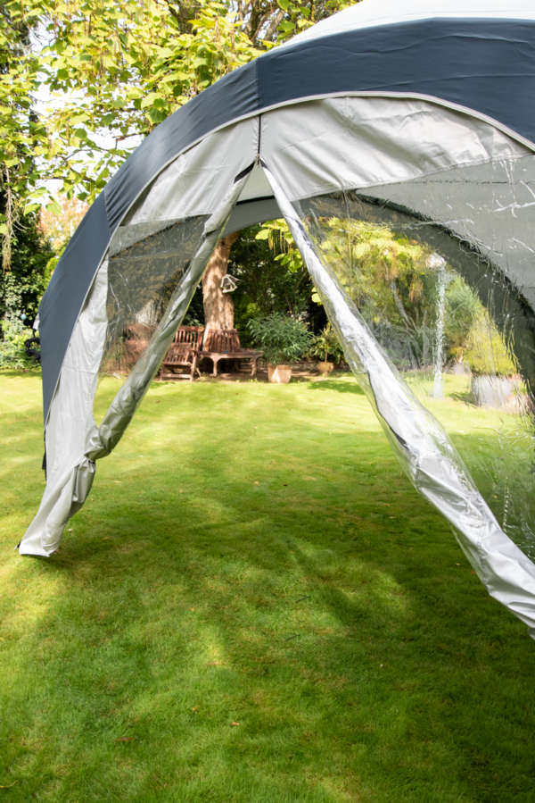 Fastpitch Shelter Sunwall with Door set up in a garden.