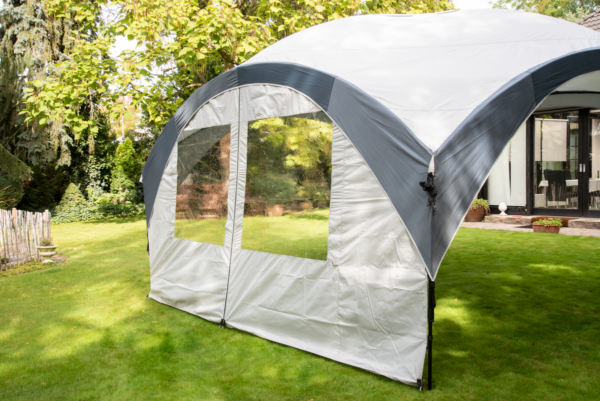 Fastpitch Shelter Sunwall with Door set up in a garden.