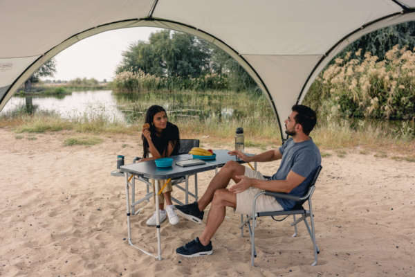 Young couple enjoying the outdoors in the comfort of a Coleman Deck chair